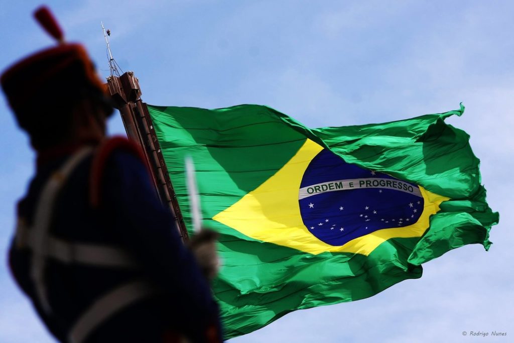 Soldado em frente à Bandeira do Brasil que está flamulando - Foto: Rodrigo Nunes